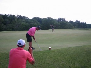 Golfers at the Putting Competition hope for a hole in one.